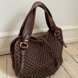 This is a Celine Macadam Bitter Sweet handbag, showcasing the brand's iconic macadam pattern. The bag features a combination of brown canvas and croc-embossed leather details, accentuated by gold-tone hardware.&nbsp;