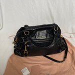 Miu Miu black nappa leather bag in a very good condition.

Crafted from nappa leather, this handbag features luxurious material and gold-tone hardware. It includes a front zip pocket, a top zip closure, and an interior slip pocket. The bag has a gold padlock charm.