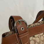 Beautiful Coach bag made from the brand’s signature canvas, with brown leather and silver hardware. Inside, there are three pockets—one with a zipper and two open.