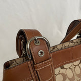 Beautiful Coach bag made from the brand’s signature canvas, with brown leather and silver hardware. Inside, there are three pockets—one with a zipper and two open.