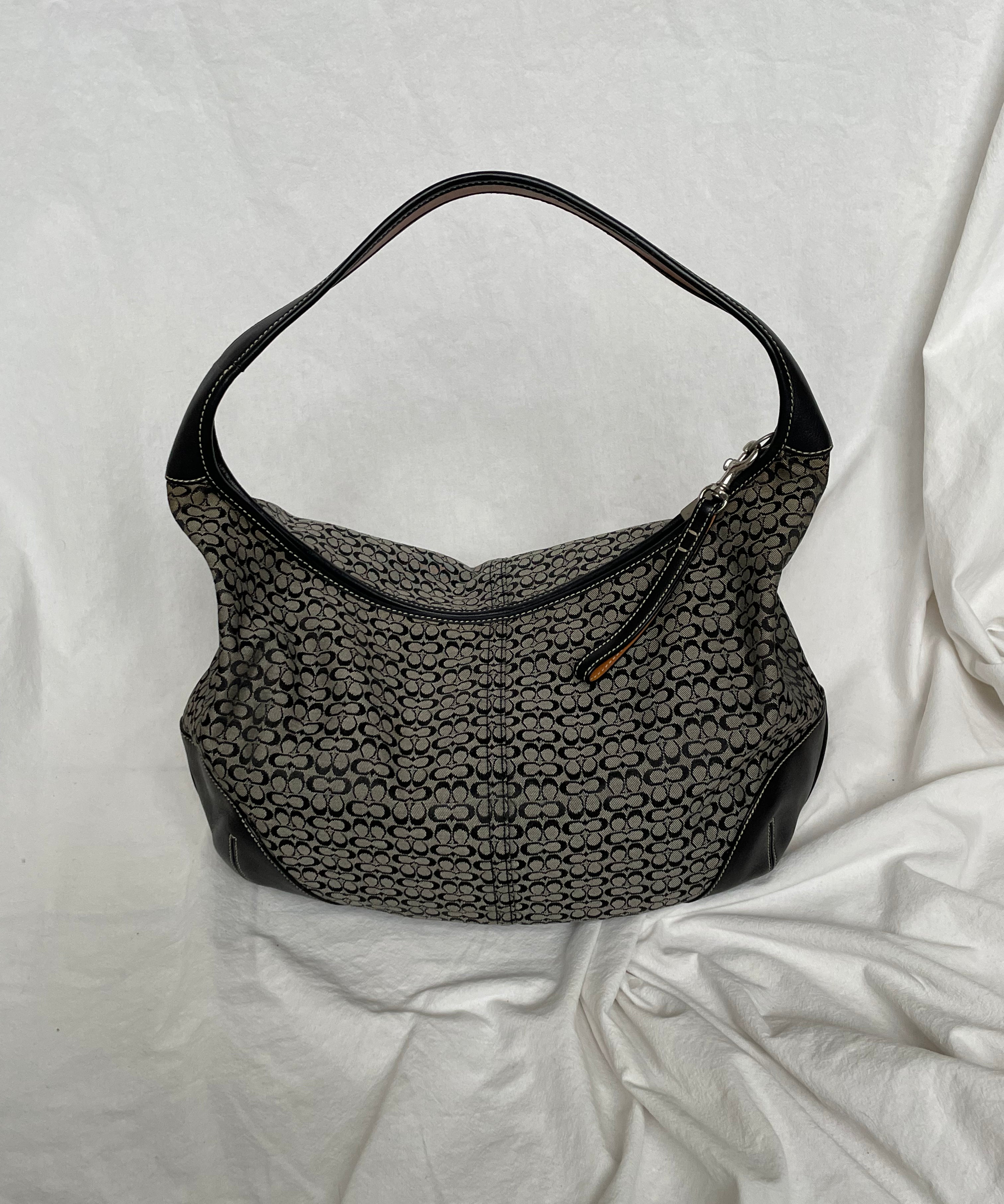 Coach shoulder bag in signature canvas and black leather, featuring one interior zip pocket. The bags condition is as good as new.