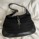 A vintage Gucci Jackie in black leather and nylon. The bag features a stylish buckle closure and a spacious interior. A timeless design perfect for any occasion.