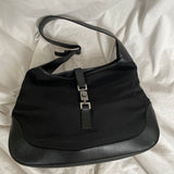 A vintage Gucci Jackie in black leather and nylon. The bag features a stylish buckle closure and a spacious interior. A timeless design perfect for any occasion.