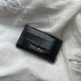 Miu Miu key wallet in black leather. Shows minor signs of wear on the hardware, but overall in very good condition