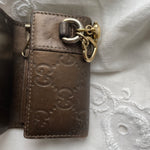 Gucci key wallet in brown leather with iconic monogram and a cute silver charm.