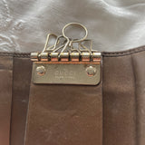 Gucci key wallet in brown leather with iconic monogram and a cute silver charm.