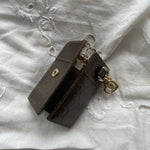 Gucci key wallet in brown leather with iconic monogram and a cute silver charm.