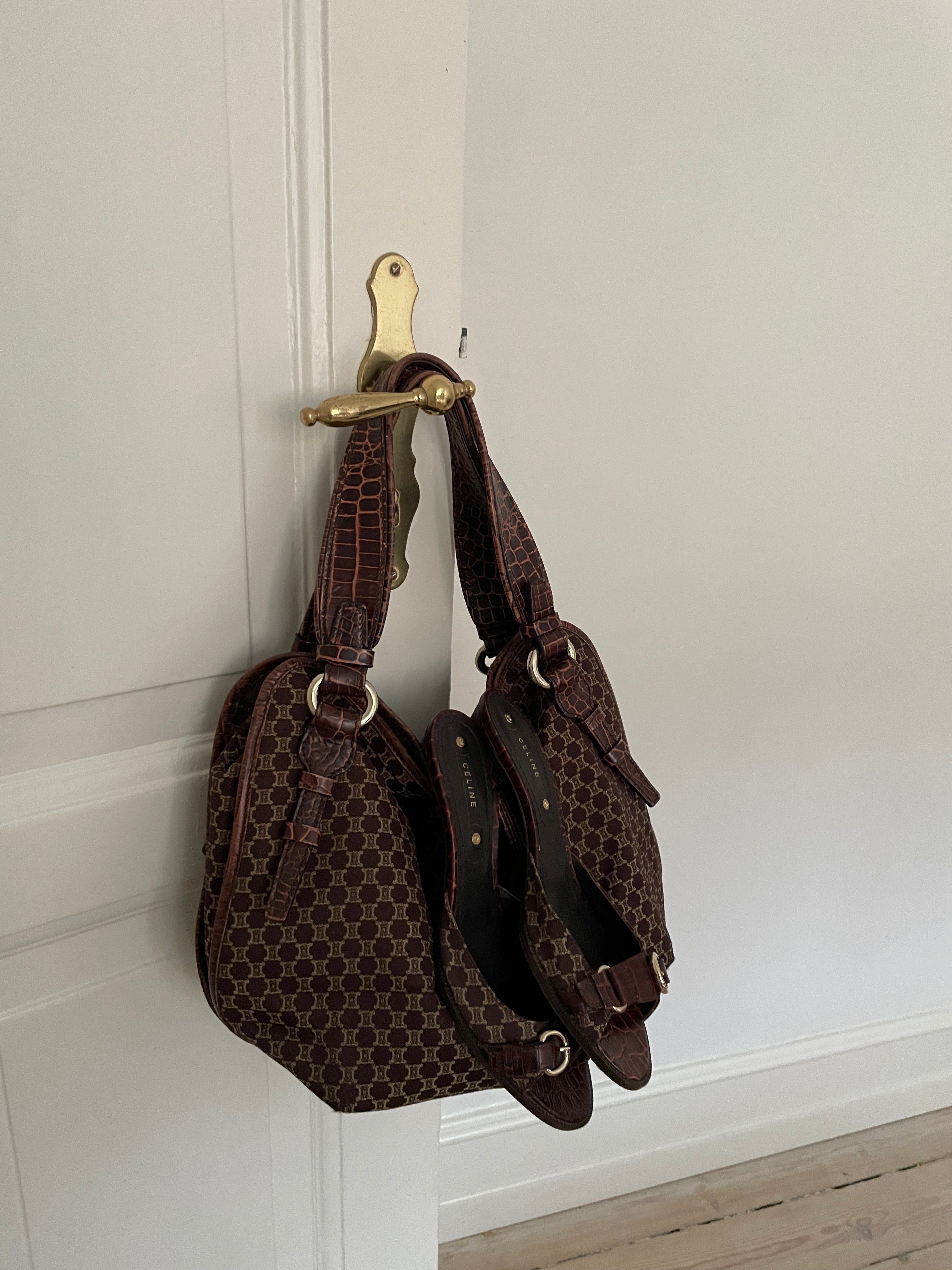 This is a Celine Macadam Bitter Sweet handbag, showcasing the brand's iconic macadam pattern. The bag features a combination of brown canvas and croc-embossed leather details, accentuated by gold-tone hardware.&nbsp;