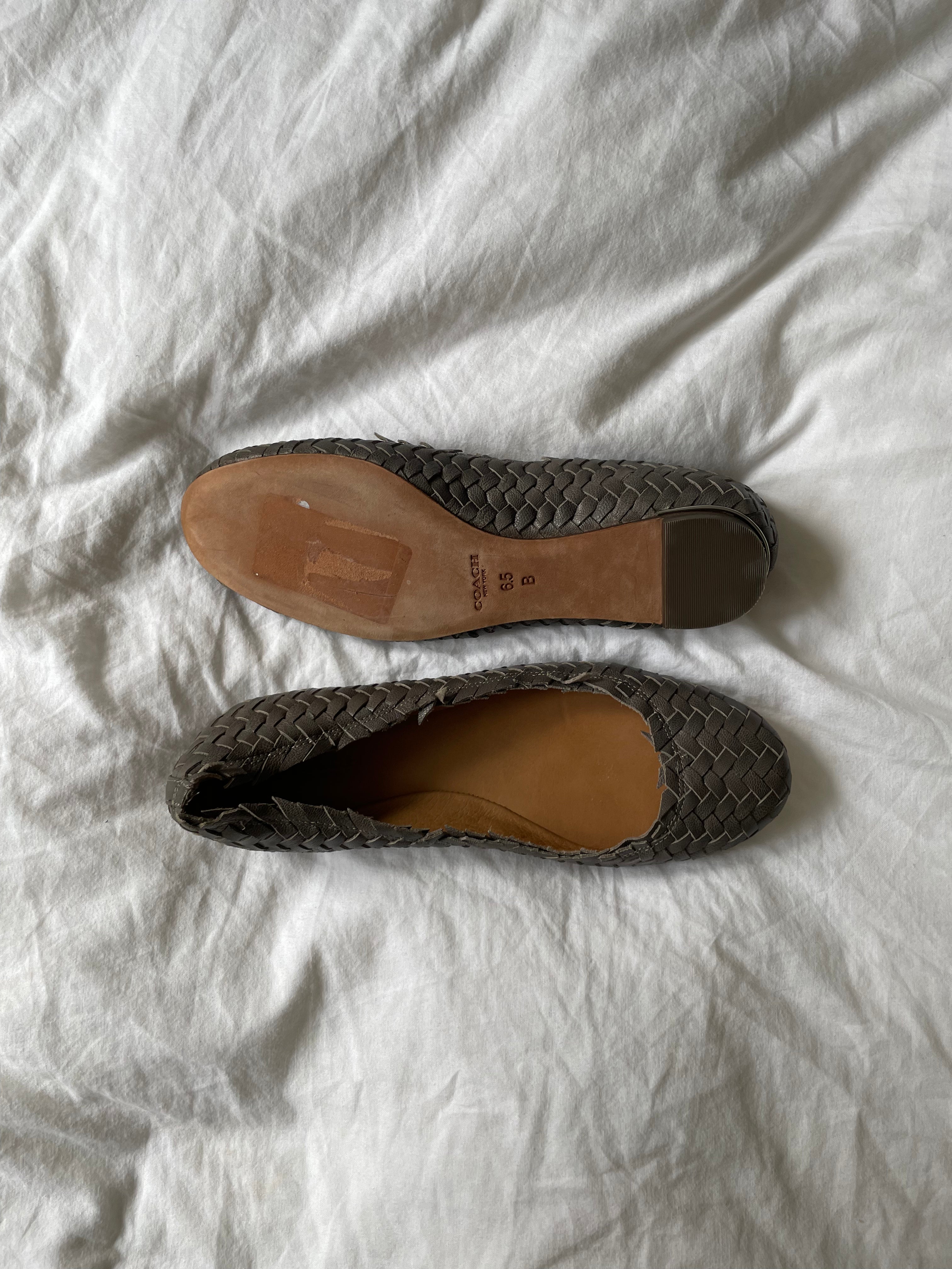 Coach woven leather ballet flats in grey with a subtle silver edge. They’re in excellent condition and show little to no signs of visible wear.