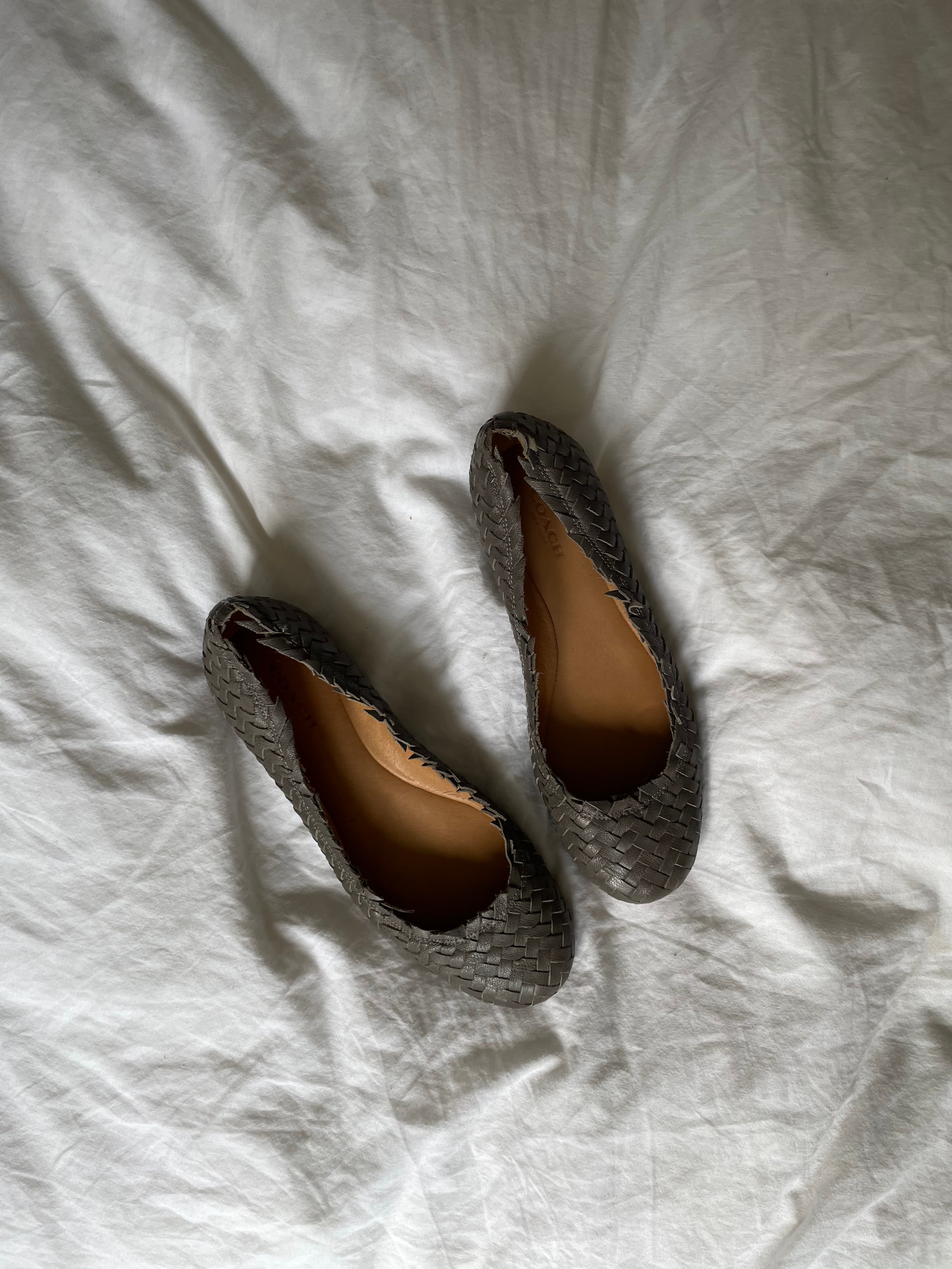 Coach woven leather ballet flats in grey with a subtle silver edge. They’re in excellent condition and show little to no signs of visible wear.