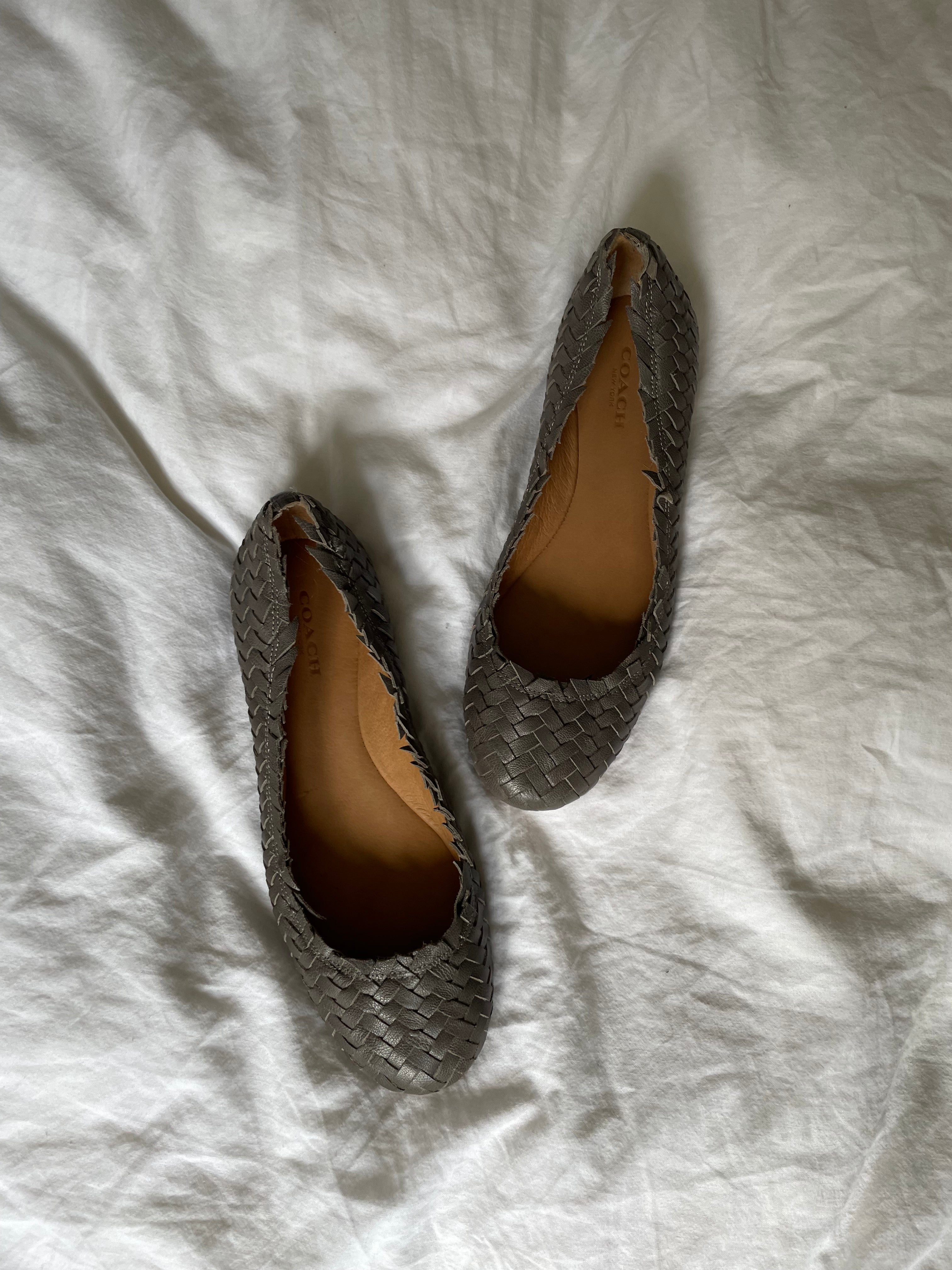 Coach woven leather ballet flats in grey with a subtle silver edge. They’re in excellent condition and show little to no signs of visible wear.