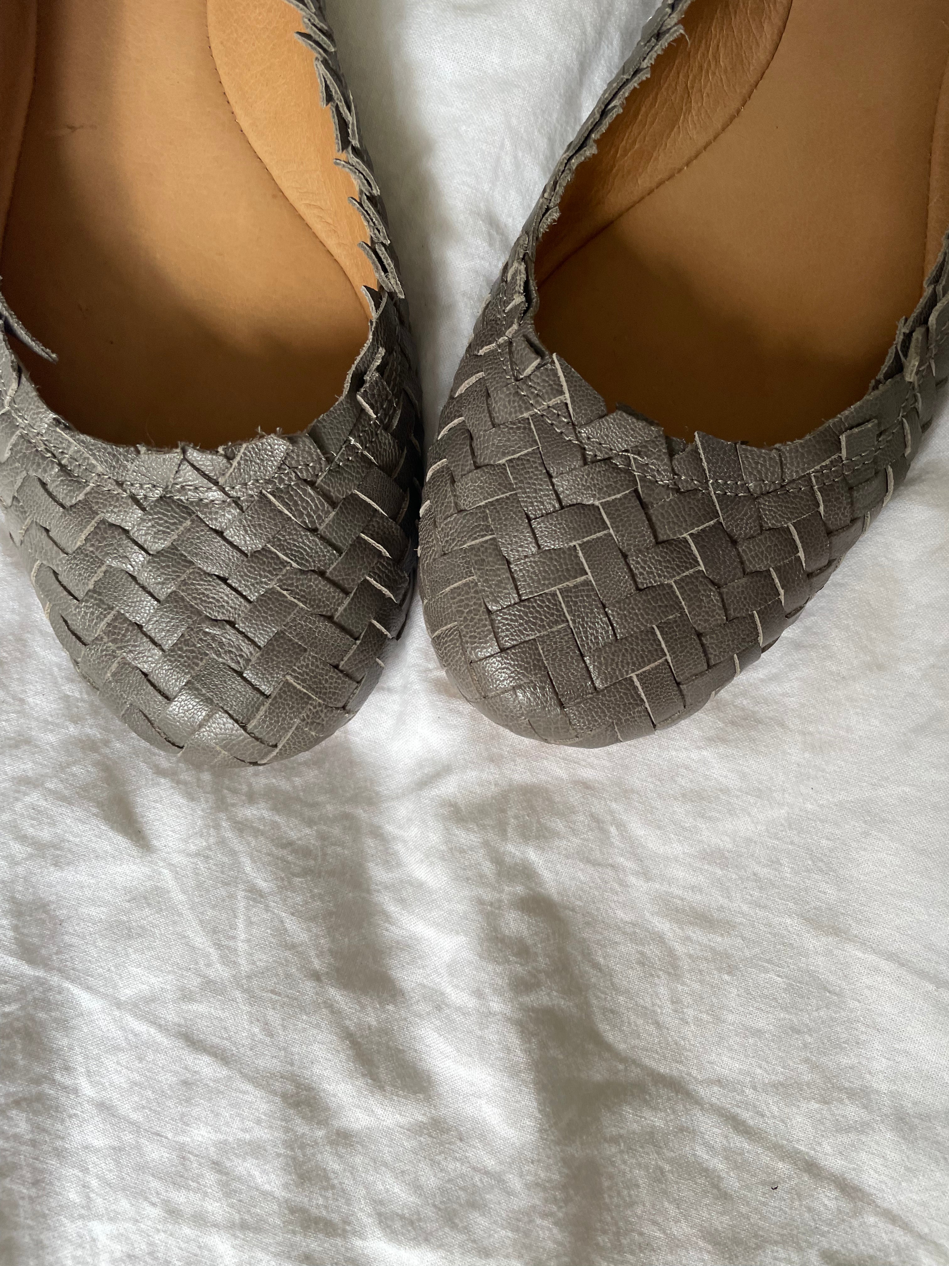 Coach woven leather ballet flats in grey with a subtle silver edge. They’re in excellent condition and show little to no signs of visible wear.