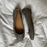 Coach woven leather ballet flats in grey with a subtle silver edge. They’re in excellent condition and show little to no signs of visible wear.