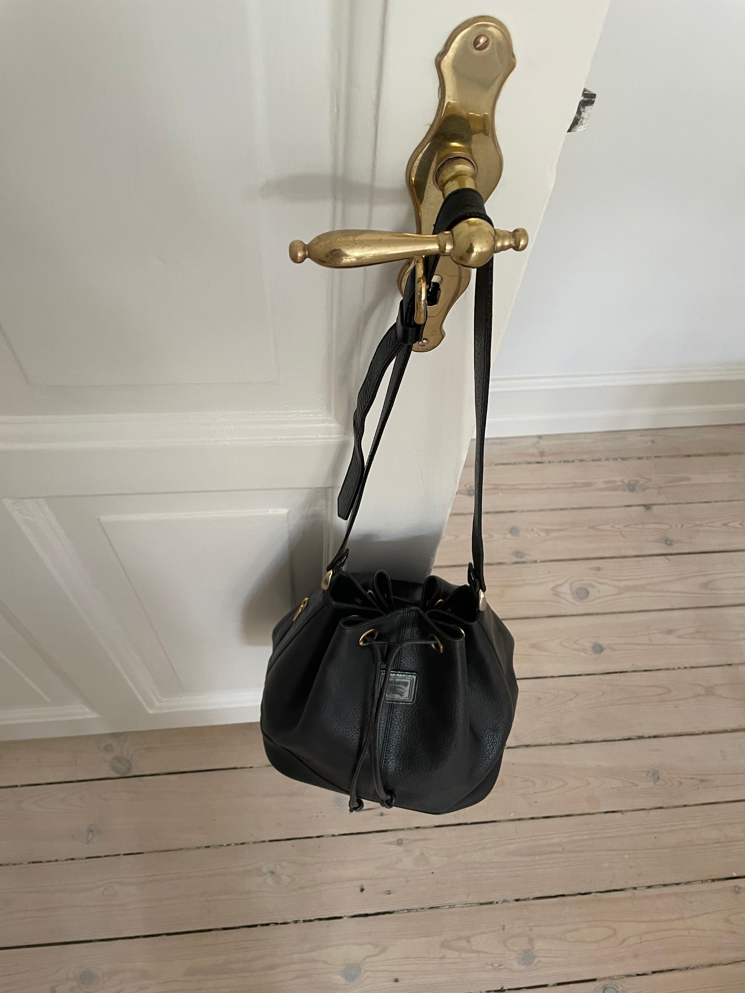 Vintage Burberrys bucket bag featuring signature canvas in the interior. The bag is overall in a good condition but the leather strap show signs of wear.&nbsp;